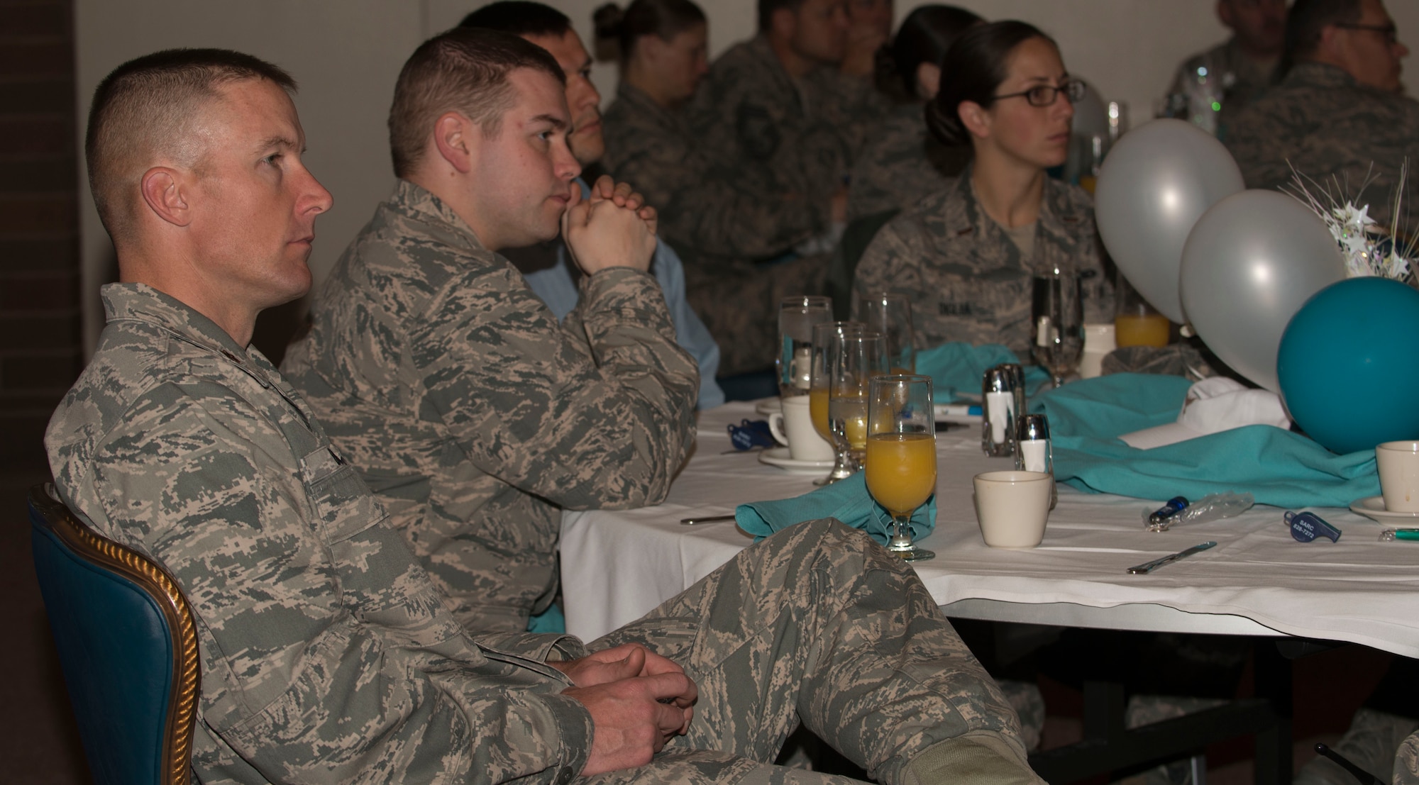 Maj. Ryan Bodge, 366th Security Forces commander, listens as Chaplain (Lt. Col.) Patrick Genseal, 366th Fighter Wing, speaks to an audience at the Sexual Assault Prevention and Response breakfast at Mountain Home Air Force Base, Idaho April 23, 2014. If Airmen have been sexually assaulted, they should call 208 828-7272 to receive help. (U.S. Air Force photo by Airman 1st Class Malissa Lott/RELEASED)