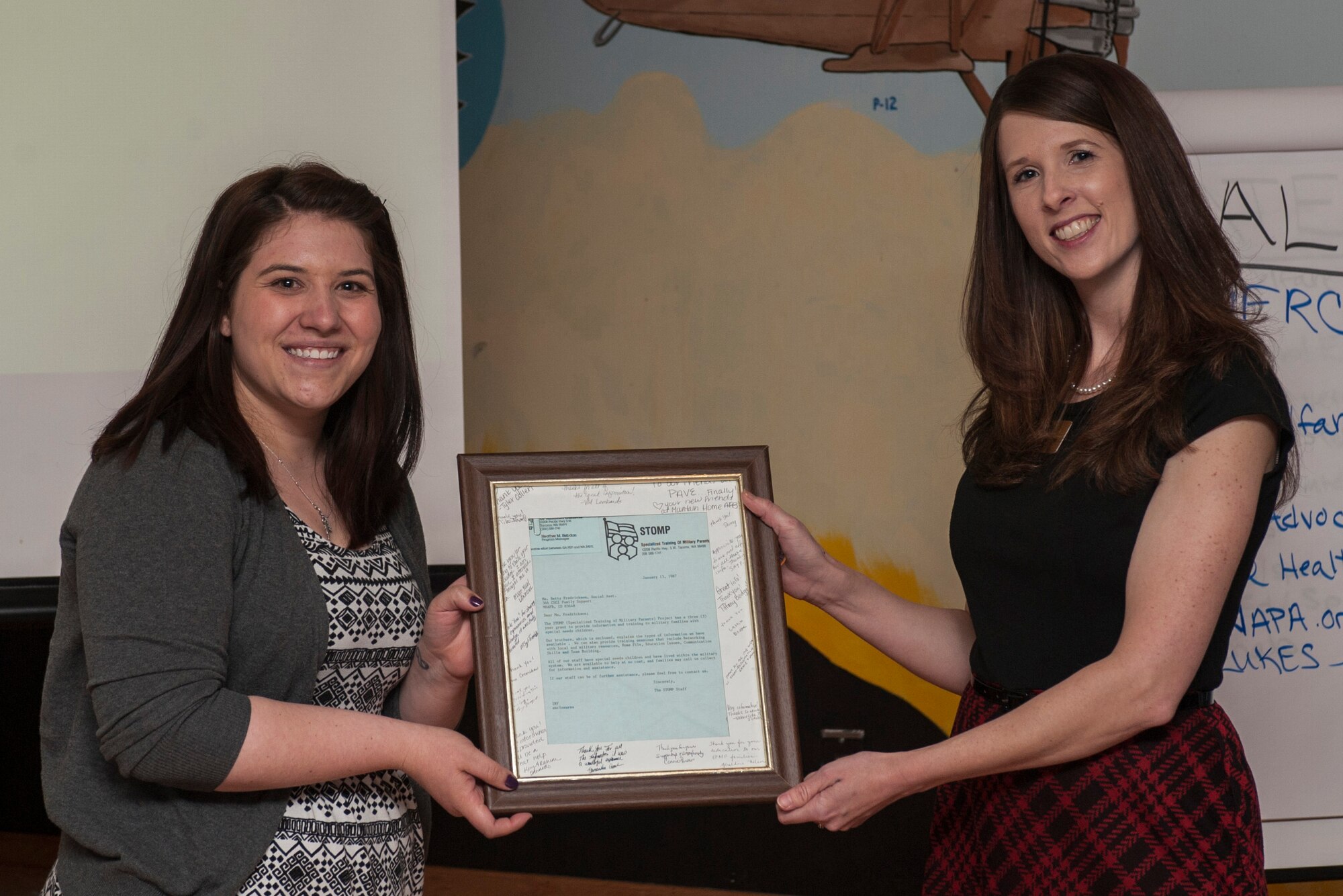 Tyler Cullen, 366th Force Support Squadron exceptional family member program coordinator, presents the original notification letter to Vicki Farnsworth, assistant program director Specialized Training of Military Parents (STOMP), during STOMP training at Mountain Home Air Force Base, Idaho, April 29, 2014. The training helps military parents find information and resources for their children that have special needs. (U.S. Air Force photo by Staff Sgt. Roy Lynch/Released)