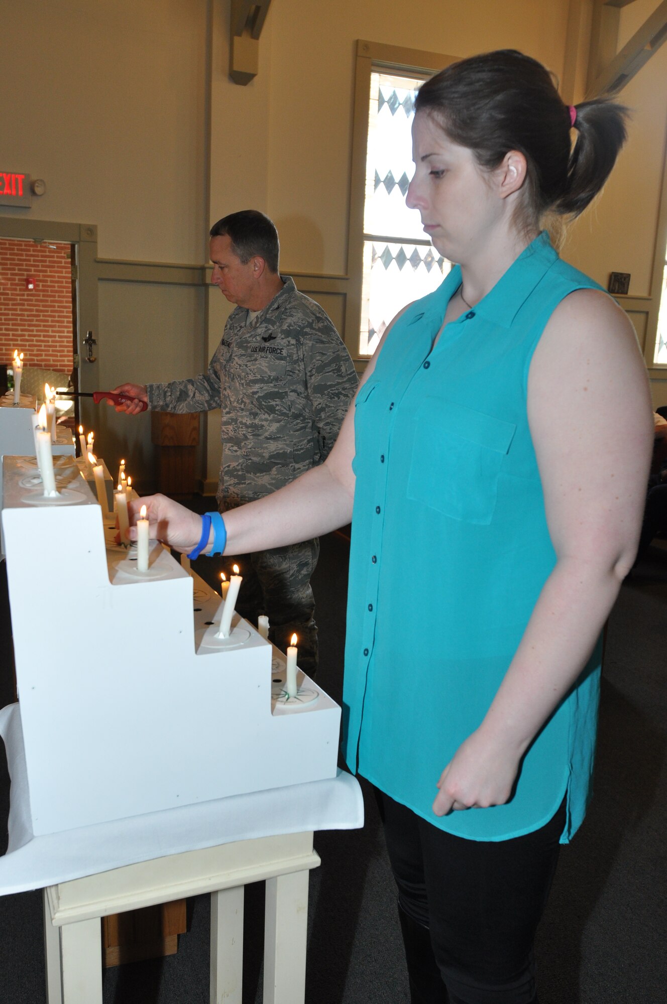 Left, Col. John Breazeale, 301st Fighter Wing commander, and Margaret Howlett, Naval Air Station Fort Worth Joint Reserve Base's Domestic Abuse Victim Advocate, join in lighting a candle for the victims who have been afflicted by a criminal tragedy in the 5th Annual Candlelight Vigil. (U.S. Air Force photo/Master Sgt. Julie Briden-Garcia)