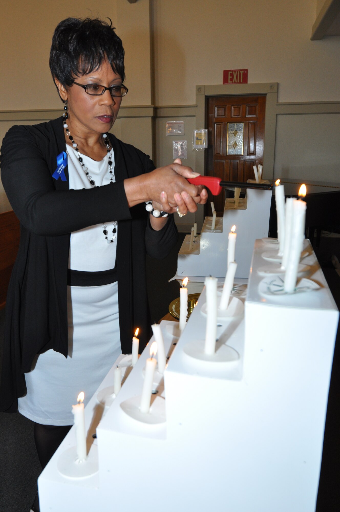 Ms. Evelyn Mickles, 301st Fighter Wing's Domestic Abuse Victim Advocate, begins the tradition of lighting a candle for those victims affect by a criminal tragedy in the 5th Annual Candlelight Vigil the Naval Air Station Fort Worth Joint Reserve Base, Texas. (U.S. Air Force photo/Master Sgt. Julie Briden-Garcia)