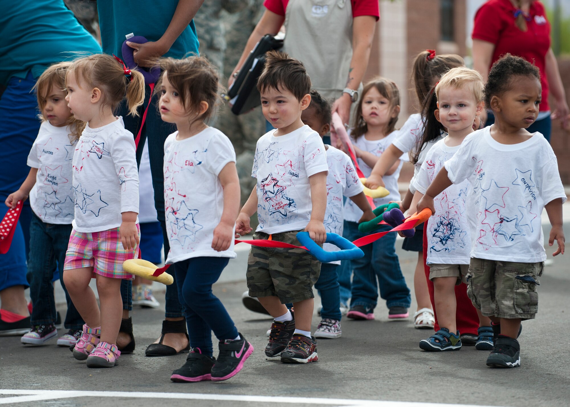 A Nellis Air Force Base Child Development Center class marches in the Month of the Military Child parade in front of the CDC April 28, 2014, at Nellis AFB, Nev. The CDC has had a different theme every weekday throughout April to celebrate Month of the Military Child. One of the activities was a classroom breakfast, where parents could join their children in the classroom for breakfast. (U.S. Air Force photo by Airman 1st Class Thomas Spangler)