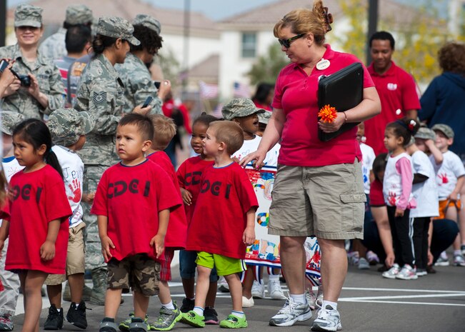 Gisela Montecerin, 99th Force Support Squadron Child Development Center teacher, leads her students along the parade route during the Month of the Military Child parade in front of the CDC April 25, 2014, at Nellis AFB, Nev. The CDC has held a parade to celebrate the Month of the Military Child for more than 15 years. (U.S. Air Force photo by Airman 1st Class Thomas Spangler)