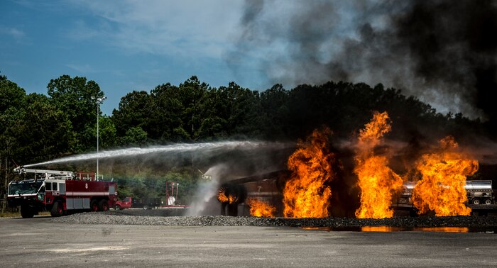 Col. Jeffrey DeVore, Joint Base Charleston commander, Capt. Timothy Sparks, JB Charleston deputy commander, Master Chief Petty Officer Joseph Gardner, Naval Support Activity command master chief, and Chief Master Sgt. Mark Bronson, 628th ABW command chief, operate a water system from a fire vehicle to put aircraft and structural fires out during a 628th Air Base Wing leadership visit April 27, 2014 at the JB Charleston Fire Department. The 628th ABW leadership visit units as part of a program designed to give base leaders a taste of what Airmen and Sailors do at their job centers every day. (U.S. Air Force photo/ Senior Airman Dennis Sloan)