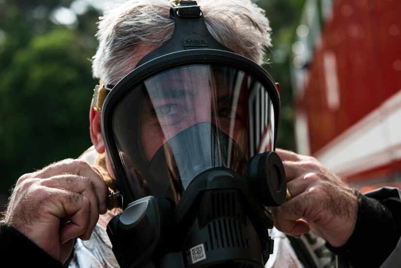 Capt. Timothy Sparks, Joint Base Charleston deputy commander, dons a mask that will deliver oxygen to him while fighting fires during a 628th Air Base Wing leadership visit April 27, 2014, at the JB Charleston Fire Department. Sparks, Col. Jeffrey DeVore, JB Charleston commander, Master Chief Petty Officer Joseph Gardner, Naval Support Activity command master chief, and Chief Master Sgt. Mark Bronson, 628th ABW command chief, visit units as part of a program designed to give base leaders a taste of what Airmen and Sailors do at their job centers every day. (U.S. Air Force photo/ Senior Airman Dennis Sloan)