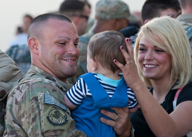 An Airman from the 820th RED HORSE reunites with his family after returning from deployment April 28, 2014, at Nellis Air Force Base, Nev. The 820th RED HORSE specializes in constructing new buildings and roadways in harsh deployed environments. (U.S. Air Force photo by Airman 1st Class Thomas Spangler)