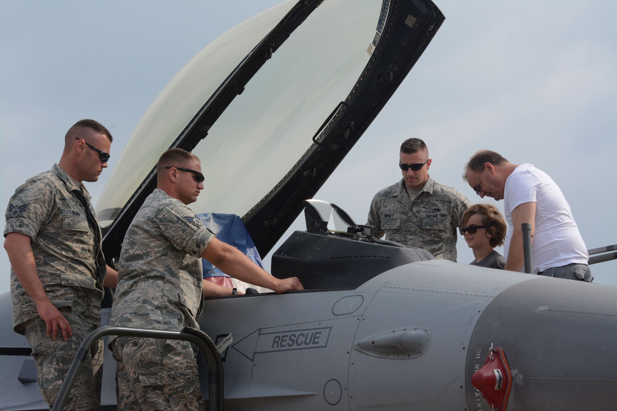 Senior Airman Frank Blaha, Senior Airman Kyle Martinez, and Senior Airman Kenny McNett all with the 301st Aircraft Maintenance Squadron speak with patrons about the F-16at the 2014 Air Power Expo at the Naval Air Station Fort Worth Joint Reserve Base, Texas. Saturday's total attendance was a single-day air show record for NAS Fort Worth JRB. (U.S. Air Force photo/Staff Sgt. Samantha Mathison)