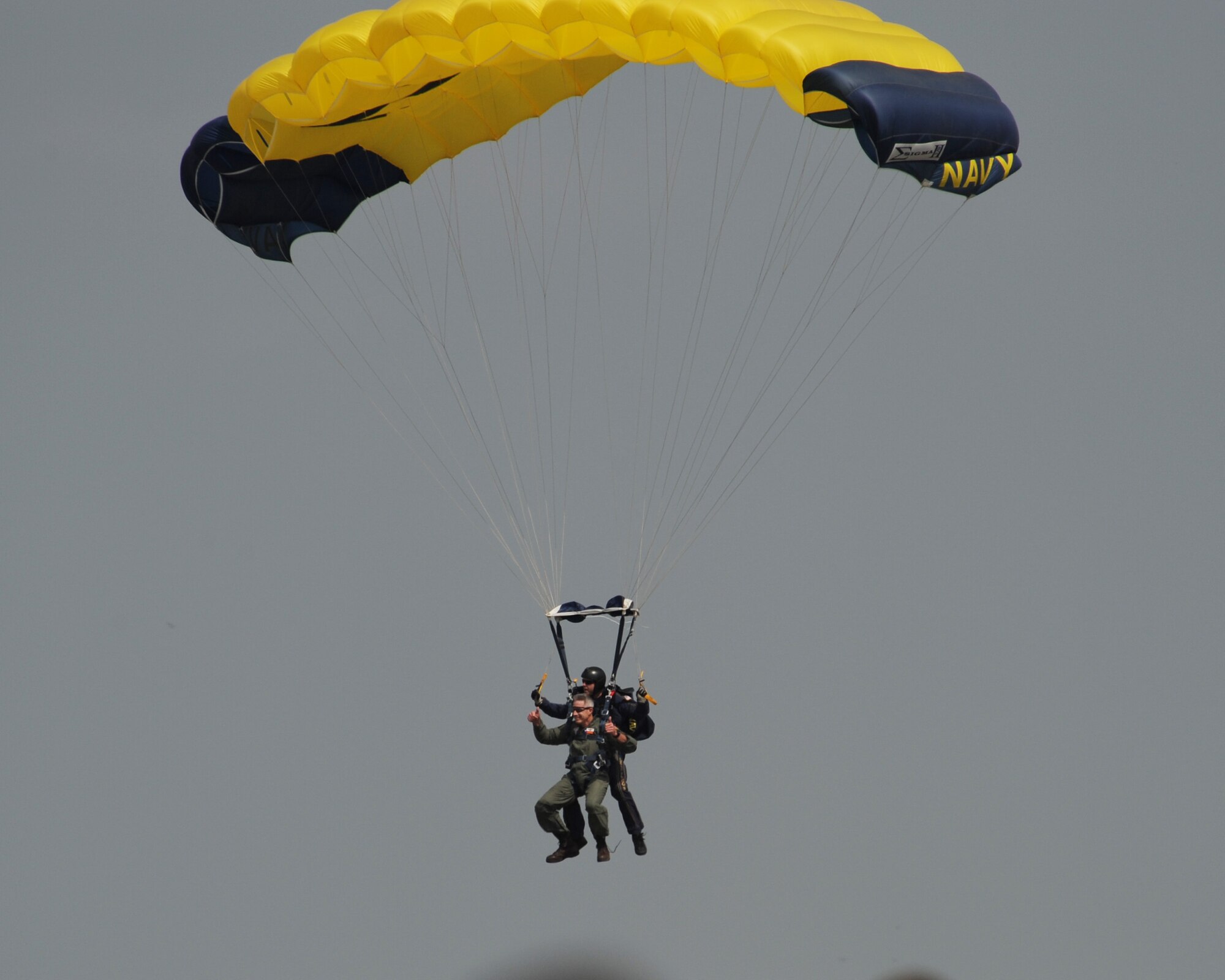 Naval Installation Commander Capt. Gil Miller gives a thumbs up just before landing with one of the Navy Leap Frogs after his tandem jump during the 2014 Air Power Expo at Naval Air Station Fort Worth Joint Reserve Base, Texas. 
Saturday's total attendance was a single-day air show record for NAS Fort Worth JRB. (U.S. Air Force photo/Mr. Rodney Ellison, Jr.)