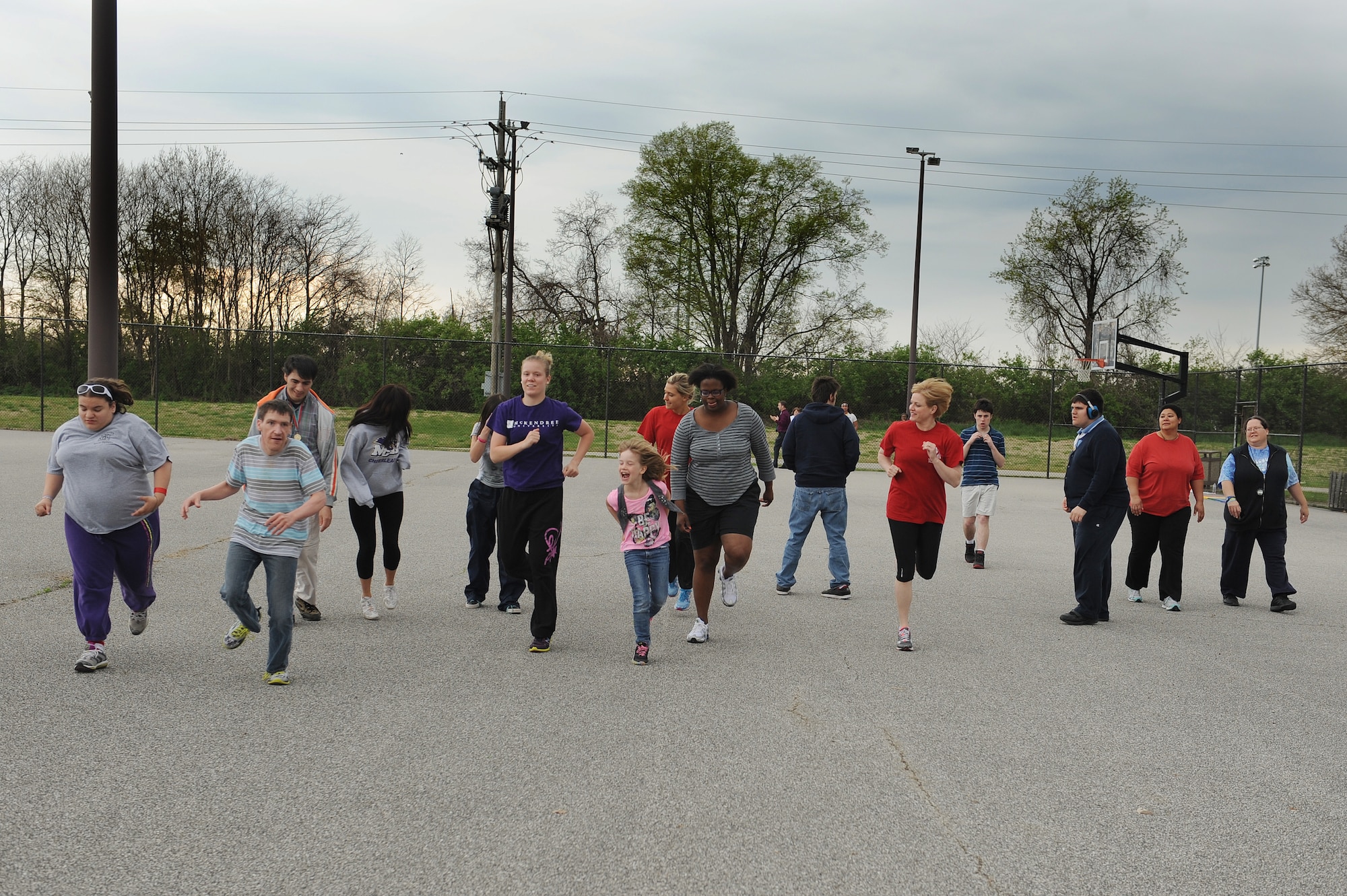Volunteers with the Exceptional Family Member Program assist people with special needs do a warm-up activity at Scott Air Force Base, Ill., April 23, 2014.  The participants trained to compete in the Special Olympics April 26 at Southern Illinois University Edwardsville.  The categories some of the athletes participated in included a ball throw, standing long jump, 50 or 100 meter walk or run.  (U.S. Air Force photo by Staff Sgt. Maria Bowman)