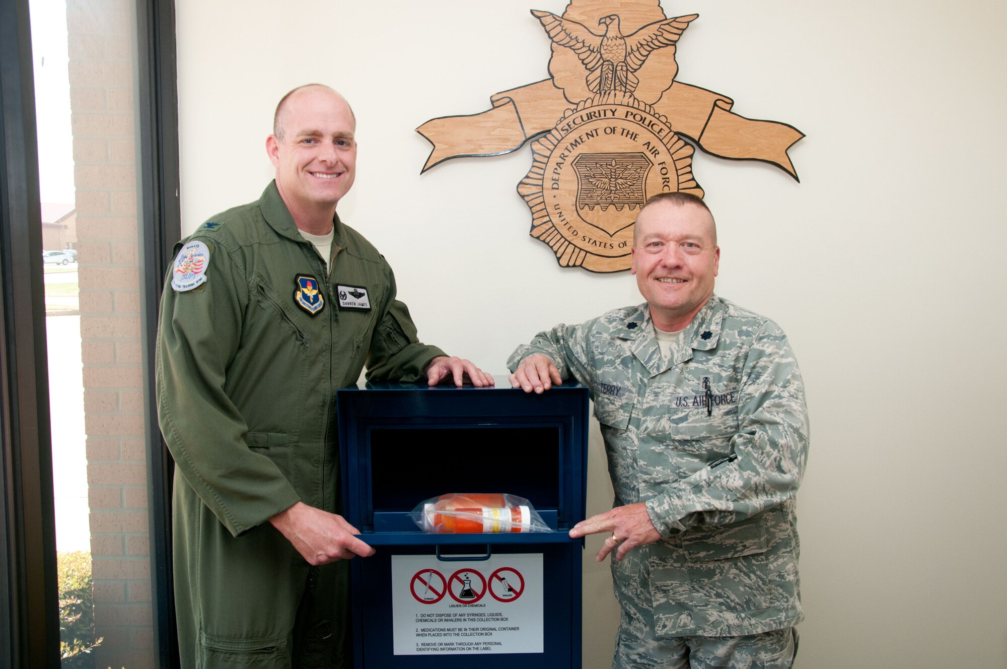 VANCE AIR FOCE BASE, Okla, -- Col. Darren James, the 71st Flying Training Wing commander, and Lt. Col. Royce Terry, the 71st Diagnostics & Therapeutics Flight commander, drop the first bottles of old, unused prescription drugs in the new Drug Disposal Box located in Building 527 April 5. The new box, the first of its kind in Air Education and Training Command, was installed in April and is the recommended way to dispose of unwanted or unused medications. (U.S. Air Force photo/Terry Wasson)