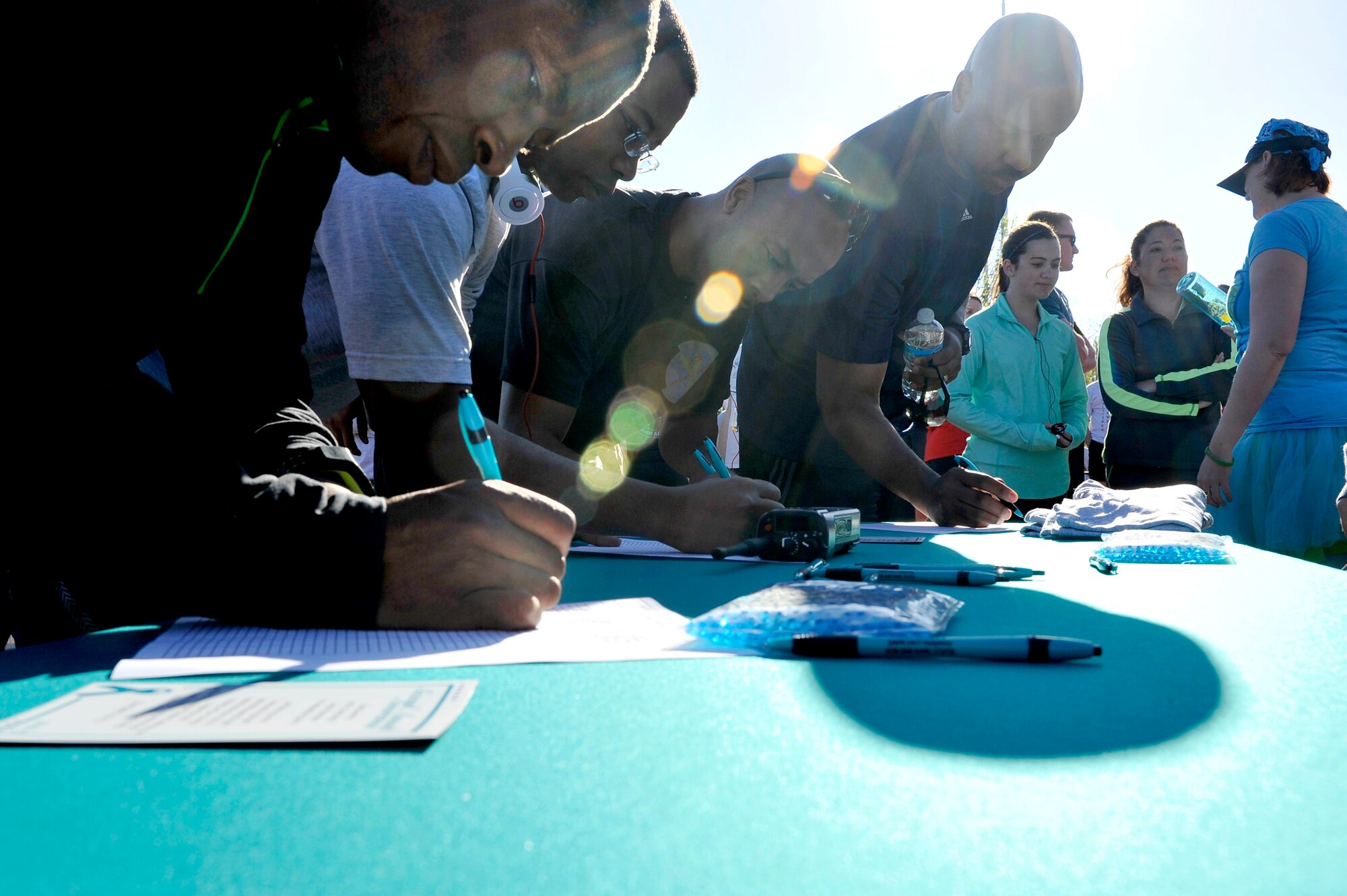 During the opening ceremony of the Sexual Assault Awareness Month 5k run, people signed in at a table to be accounted for April 25, 2014 at Scott Air Force Base, Ill. The run began at the base parade field where Master Sgt. Pamela King gave opening remarks about the event. King and others have hosted events during the month of April to raise awareness and prevention for sexual assault. (U.S. Air Force photo/ Airman 1st Class Kiana Brothers)