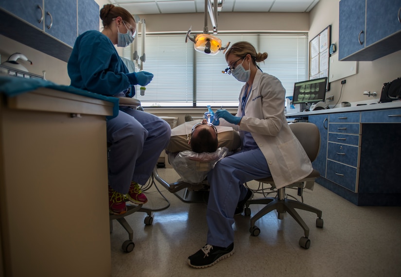 Lea Gillis, 628th Medical Group dental assistant (left), and Capt. Mary Sorrentino, 628th Aerospace Medicine Squadron general dentist (right), perform a routine dental examination on Airman 1st Class Craig Luce, 437th Ariel Port Squadron cargo processor Apr. 16, 2014, at the 628th Medical Group dental clinic on Joint Base Charleston – Air Base, S.C. Gillis makes sure that the operation runs smoothly and assists Sorrentino as she performs the dental procedures. (U.S. Air Force photo/ Airman 1st Class Clayton Cupit)