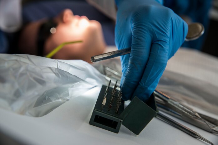 Capt. Mary Sorrentino, 628th Aerospace Medicine Squadron general dentist, reaches for a dental instrument during a routine examination on Airman 1st Class Craig Luce, 437th Ariel Port Squadron cargo processor,  Apr. 16, 2014, at the 628th Medical Group dental clinic on Joint Base Charleston – Air Base, S.C. Instruments are thoroughly cleaned and sterilized every. (U.S Air Force photo/ Airman 1st Class Clayton Cupit)