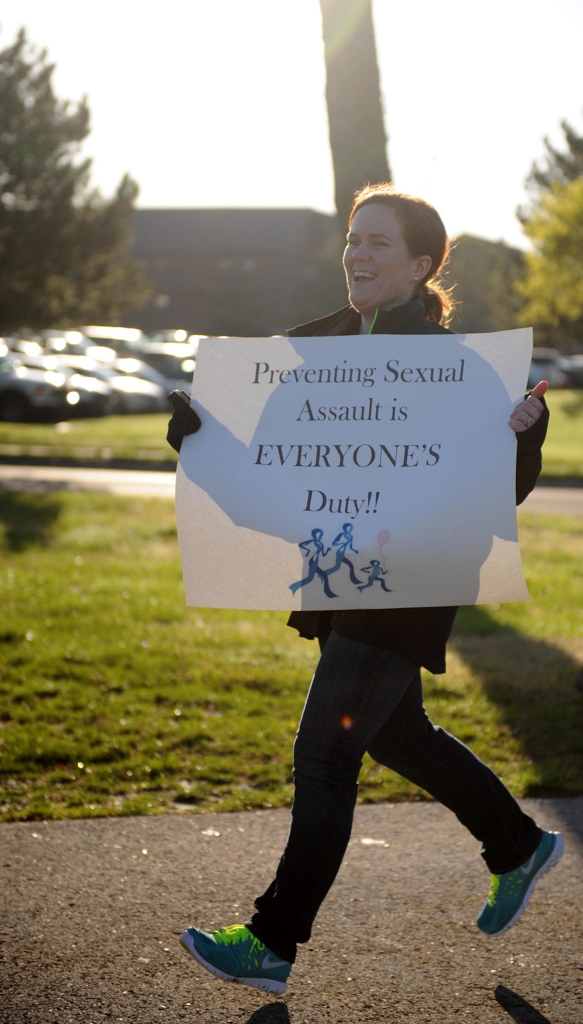 Katherine Felder, a victims advocate, crosses the finish line during the 5K Race for Respect at Whiteman Air Force Base, Mo., April 25, 2014. Victim advocates were placed along the route with various signs displaying facts about sexual assault. (U.S. Air Force photo by Airman 1st Class Joel Pfiester/Released)