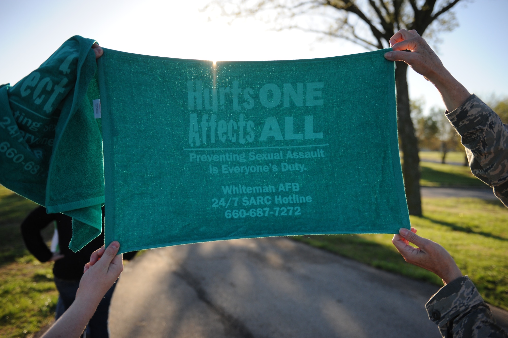 Volunteers hold up a Whiteman Air Force Base Sexual Assault Response Coordinator towel during the 5K Race for Respect at Whiteman Air Force Base, Mo., April 25, 2014. Upon completing the run participants were given towels, water bottles and T-shirts. (U.S. Air Force photo by Airman 1st Class Joel Pfiester/Released)