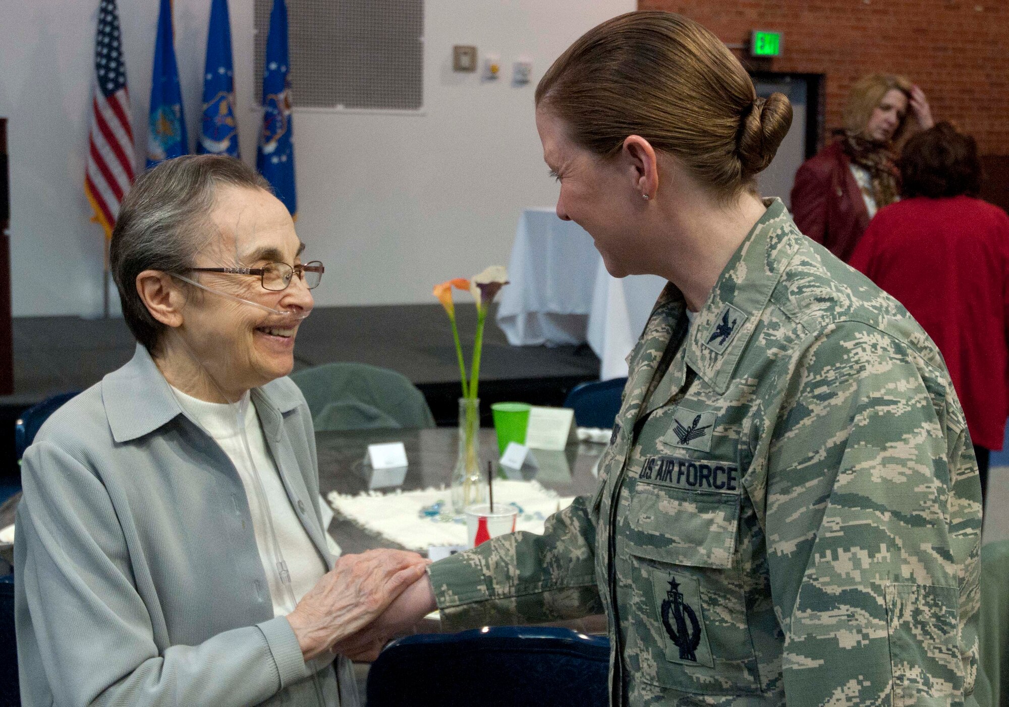 Helen Zigmond, a holocaust survivor, talks with Col. Tracey Hayes, 90th Missile Wing commander, during the Holocaust Observance event April 29 in the Fall Hall Community Center. Zigmond and her brother Zoltan Gancz were honored guests for the event.  (U.S. Air Force photo by Airman Malcolm Mayfield)
