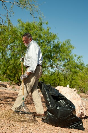 Fred Zorbas, 99th Civil Engineer Squadron air quality manager, rakes up debris during a Maj. Gen. Billy McCoy Environmental Grove cleanup event April 24, 2014 at Nellis Air Force Base, Nev. The grove is used as a reminder to Airmen to conserve the earth's natural resources and stay environmentally conscious. (U.S. Air Force photo by Airman 1st Class Timothy Young)