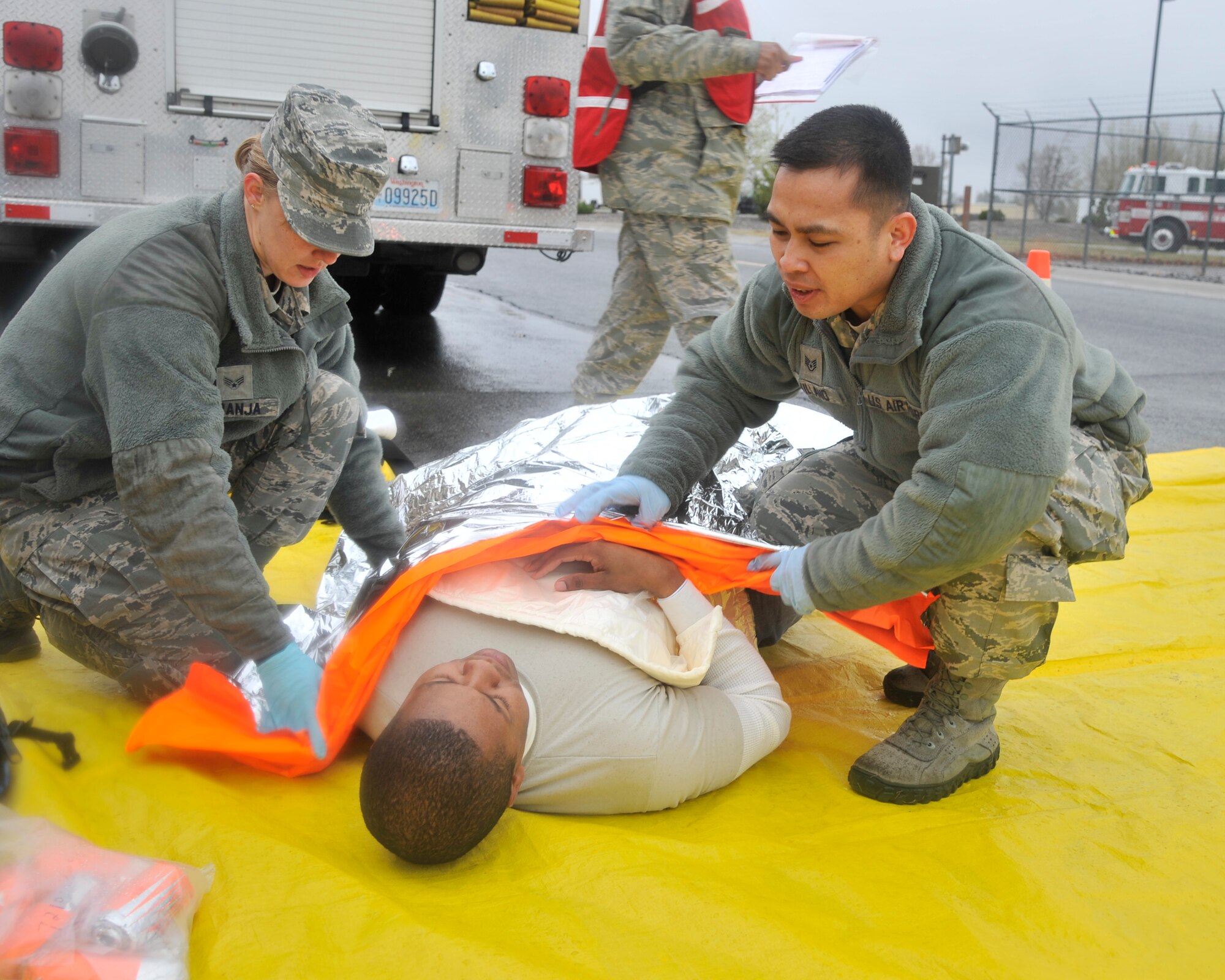 Members of Team Fairchild transport a simulated patient during an exercise at Fairchild Air Force Base, Wash., April 22, 2014. The installation's emergency responders worked alongside partnering agencies from around the community to ensure seamless operations, especially during a crisis. This exercise was held in preparation for the upcoming Skyfest open house and air show. (U.S. Air Force photo by Senior Airman Mary O'Dell/Released)