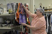 Barbara Bryant, Joint Base San Antonio-Randolph Thrift Shop manager, arranges handbags March 19 at the shop. (U.S. Air Force photo by Joel Martinez)