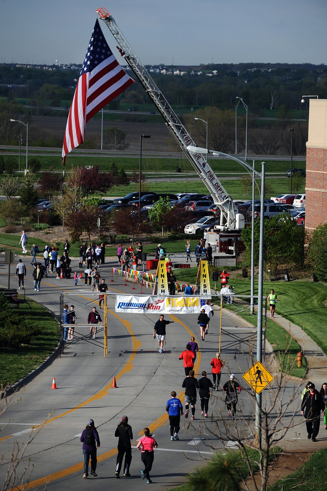 Runners make their to the finish line of the sixth annual Bellevue-Offutt Runway Run at the Bellevue Lied Activity Center in Bellevue, Neb., May 12, 2013. More than 200 runners participated in this unique seven-mile race that takes runners down the Offutt Air Force Base runway amid a formation of Air Force air craft. (U.S. Air Force Photo by Josh Plueger)
