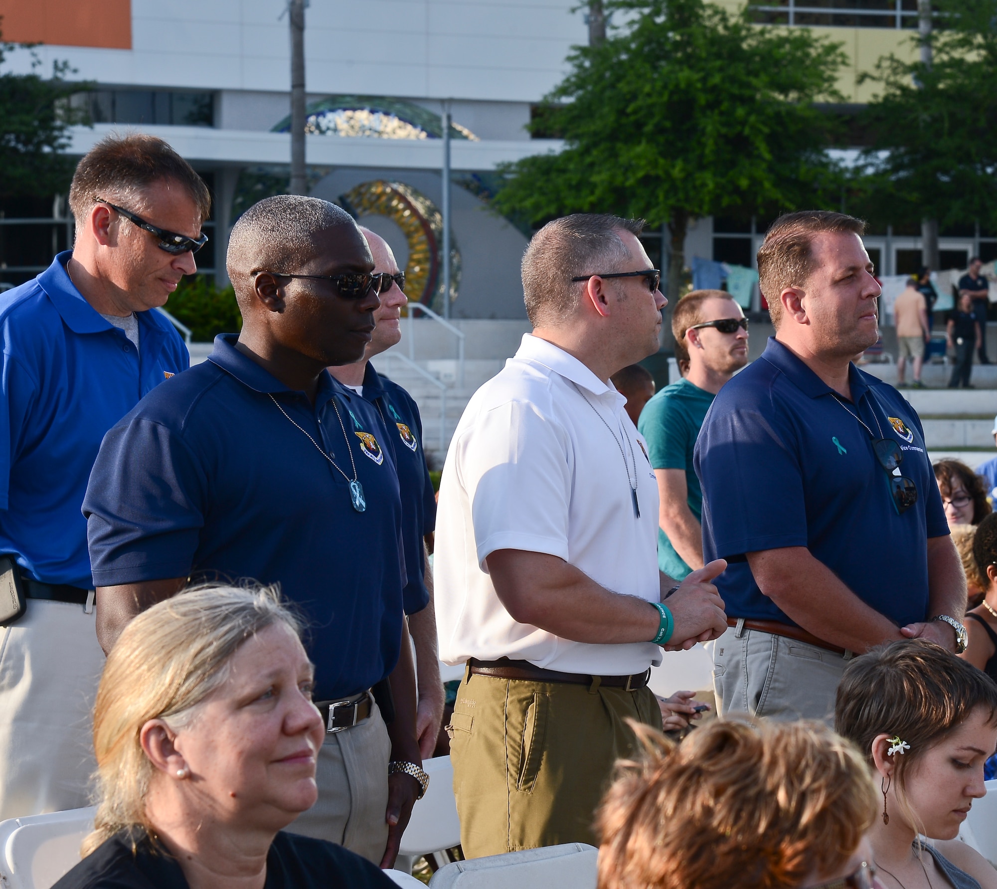 (From left) Col. Reginald Godbolt, 6th Maintenance Group commander, Chief Master Sgt. Thomas Mazzone, 6th Air Mobility Wing command chief, and Col. Andre Briere, 6th Air Mobility Wing vice commander, stand to take a pledge at the Sexual Violence Task Force of Tampa Bay’s, in collaboration with the Crisis Center of Tampa Bay, “Take Back the Night” event at Curtis Hixon Park in Tampa, Fla., April 27, 2014. All the men in the audience were invited to stand and take a pledge to help end sexual violence. (U.S. Air Force photo by Airman 1st Class Vernon L. Fowler Jr./Released)