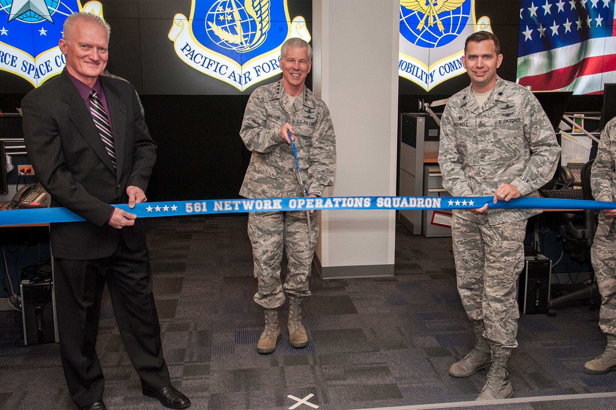 PETERSON AIR FORCE BASE, Colo. – Gen. William Shelton (center), Air Force Space Command commander, cuts the ribbon held by Lt. Col. Roy Rockwell, 561st Network Operations Squadron commander, and Clifford Goodnight, 561st NOS civilian deputy, for the 561st NOS ribbon cutting ceremony April 28. The 561st NOS uses cyberspace in joint operations to defend its portion of the Department of Defense network, which enhances the overall ability of the U.S. government to protect national security. (U.S. Air Force photo/Craig Denton)