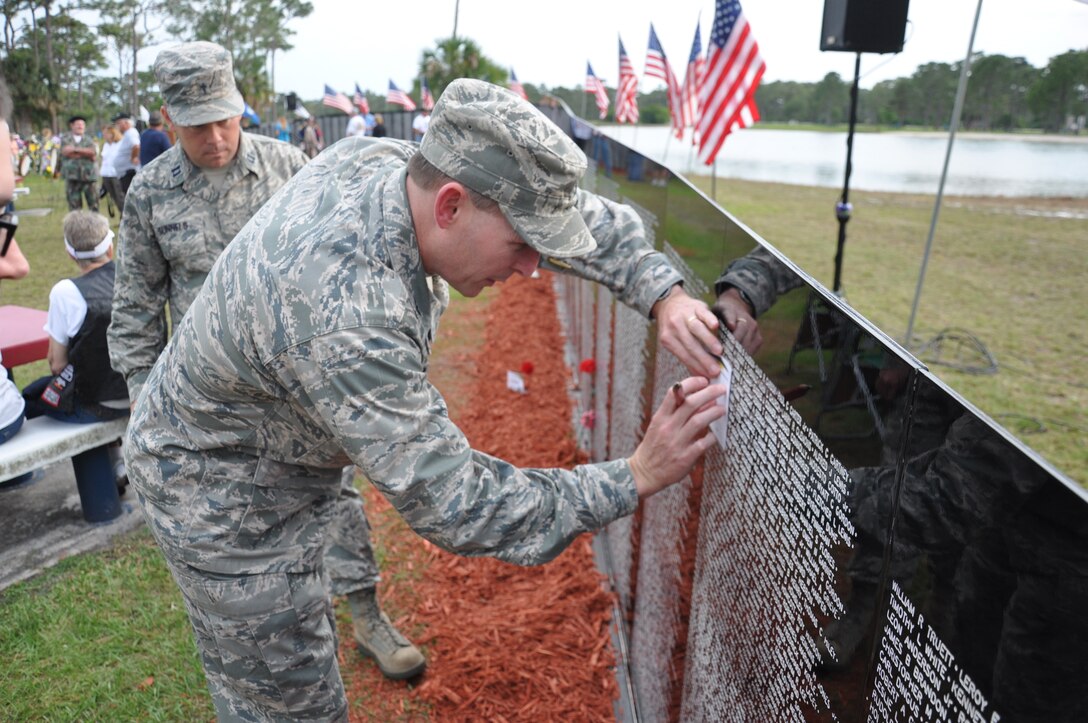 Col. Patrick Donley, 45th Mission Support Group commander, places a piece of paper over a name on the wall to rub it over with a pencil, while Chaplain (Capt.) Jason Gunnels, 45th Space Wing looks on, during the 27th Annual Florida Vietnam and All Veterans Reunion at Wickham Park in Melbourne, Fla. April 28. Donley opened the ceremony as the first guest speaker and shared stories about the history of his favorite Vietnam hero, U.S. Air Force Sergeant Louis Harold Fischer of the 377th Security Police Squadron. (U.S. Air Force photo/Capt. Erin Dorrance) 