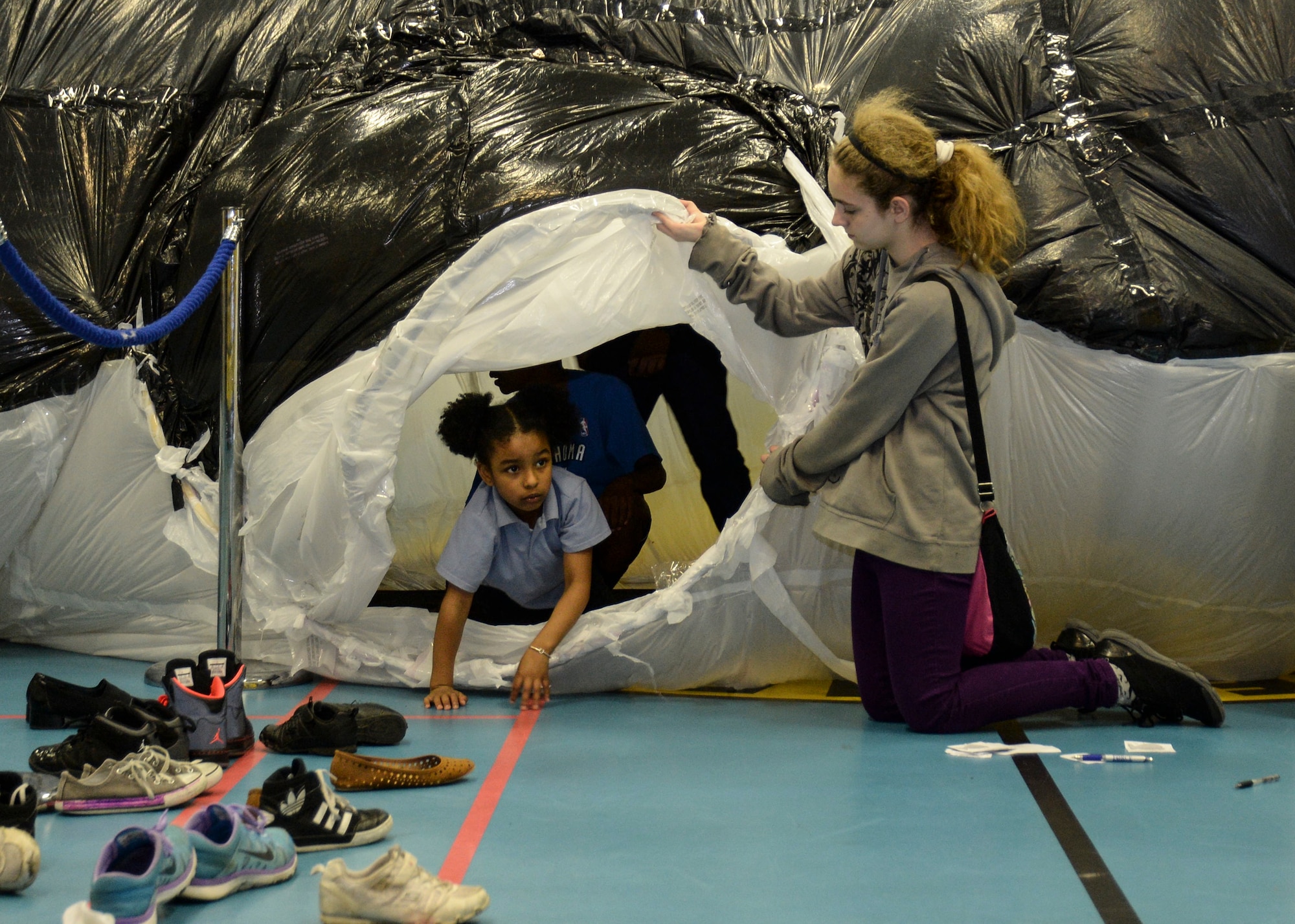 Nataliya Roa, 6, exits a plastic whale at the Lakenheath Middle School science fair on Royal Air Force Feltwell, England, April. 28, 2014. The whale, constructed of only trash bags, took students more than 6 months to complete. Nataliya is the daughter of Senior Master Sgt. Felix Roa, 100th Logistics Readiness Squadron flight chief, and Master Sgt. Karian Roa, 100th Refueling Wing inspection superintendent. (U.S. Air Force photo by Airman 1st Class Nigel Sandridge/Released)