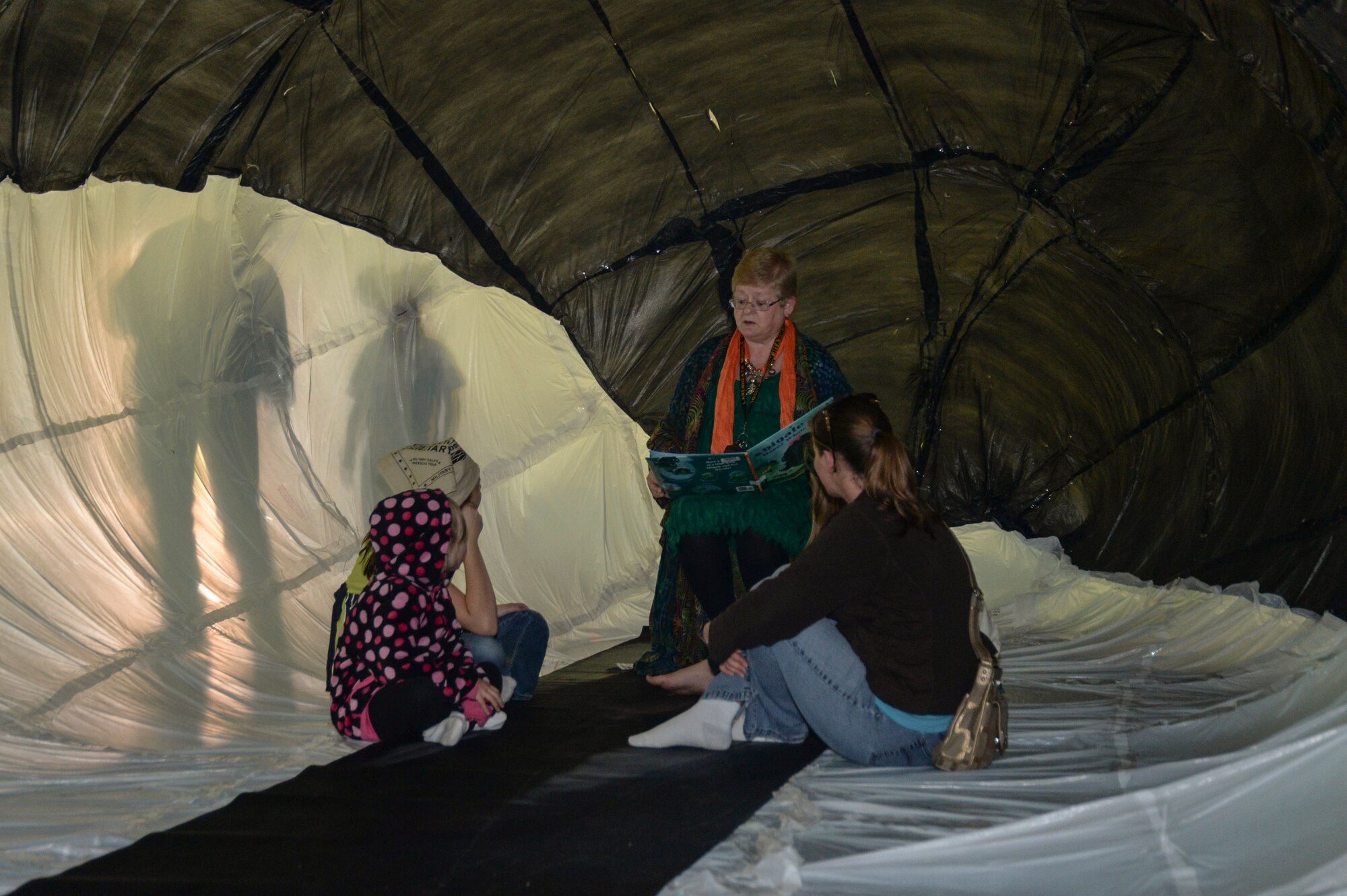 Emma Espinosa, sixth-grade social studies teacher, reads to children inside the Lakenheath Middle School Science Club’s handmade whale at the school science fair on Royal Air Force Feltwell, England, April 28, 2014. The whale, constructed of only trash bags, took students more than six months to complete. (U.S. Air Force photo by Airman 1st Class Nigel Sandridge/Released)