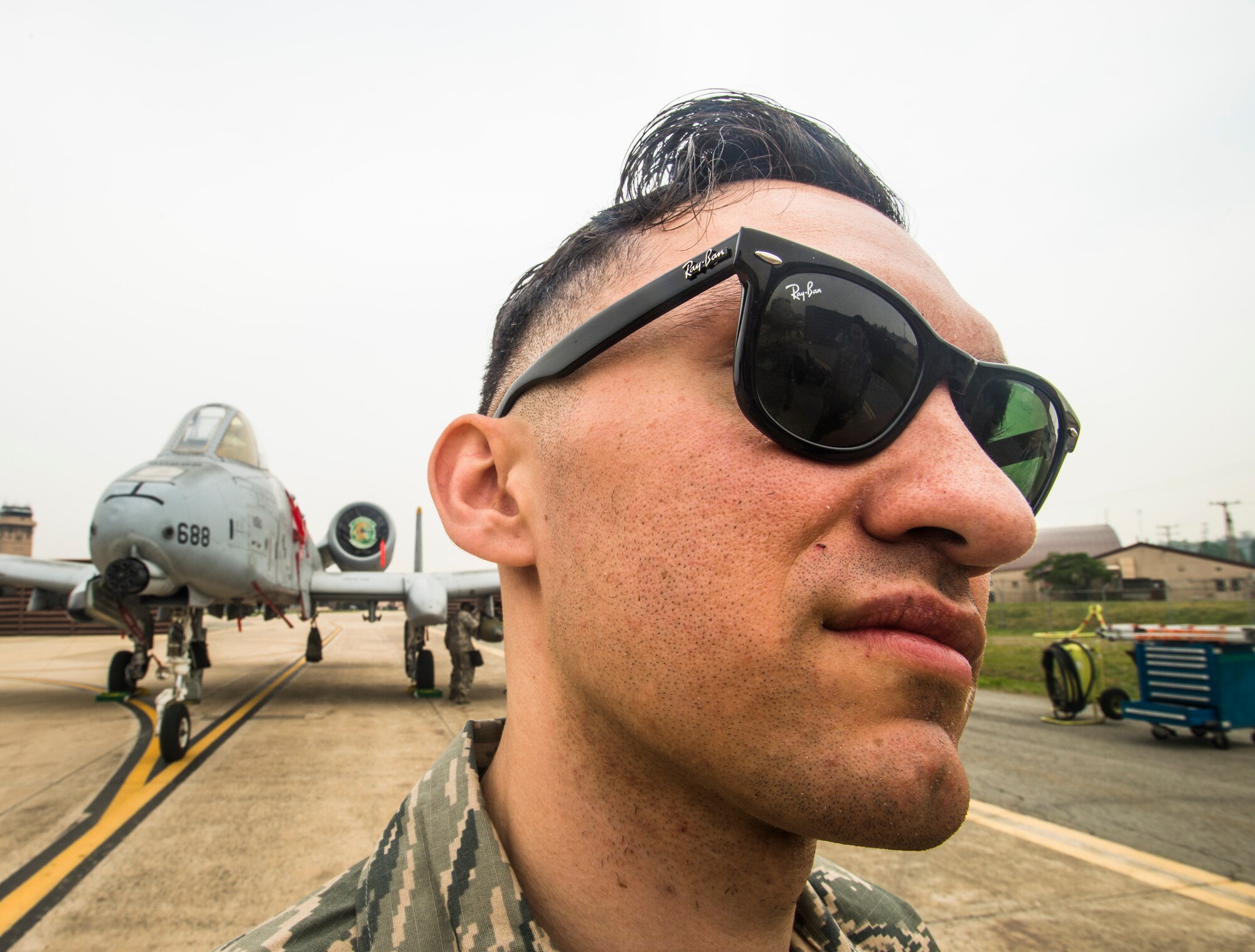 Senior Airman Juan Gonzalez, a 25th Aircraft Maintenance Unit weapons load crew member, reflects on his team's victory in front of their A-10 during the 2014 Korean Peninsula Weapons Loading Competition April 26, at Osan Air Base, Republic of Korea. Gonzalez, and his team members, Senior Airmen, Jacob Jennings and Chandler Rickard, will go on to compete at higher levels. (U.S. Air Force photo by Staff Sgt. Jake Barreiro)