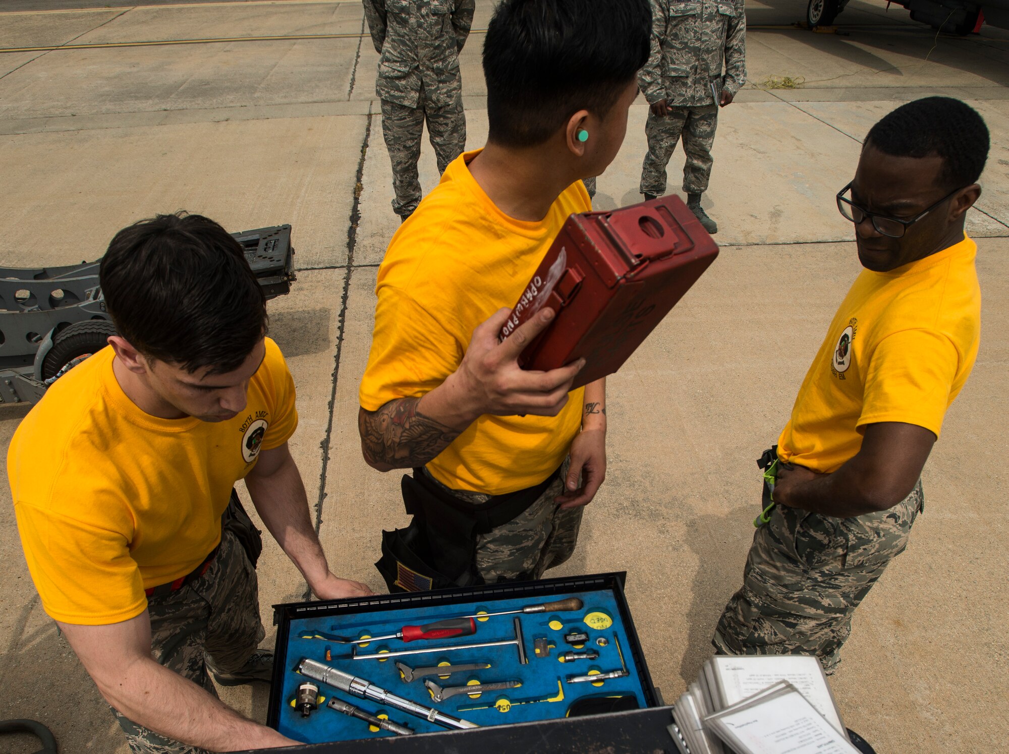 The 80th Aircraft Maintenance Unit weapons load crew team from Kunsan Air Base, Republic of Korea, searches for tools during the 2014 Korean Peninsula Weapons Loading Competition April 26, at Osan Air Base. The members of the 80th AMU weapons load crew team are Senior Airman Stephen Jervis, Senior Airman Ryanted Duarte and Staff Sgt. Jermaine Cox. (U.S. Air Force photo by Staff Sgt. Jake Barreiro)