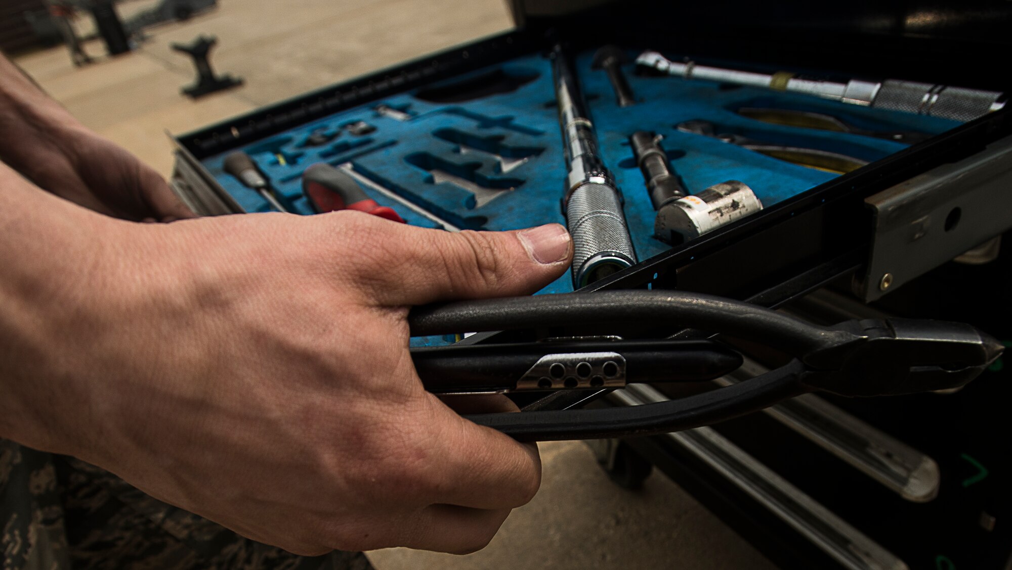 Senior Airman Stephen Jervis, an 80th Aircraft Maintenance Unit weapons load crew member at Kunsan Air Base, Republic of Korea, looks for tools during the 2014 Korean Peninsula Weapons Loading Competition April 26, at Osan Air Base. The winning load crew completed the competition in 12:35. (U.S. Air Force photo by Staff Sgt. Jake Barreiro)