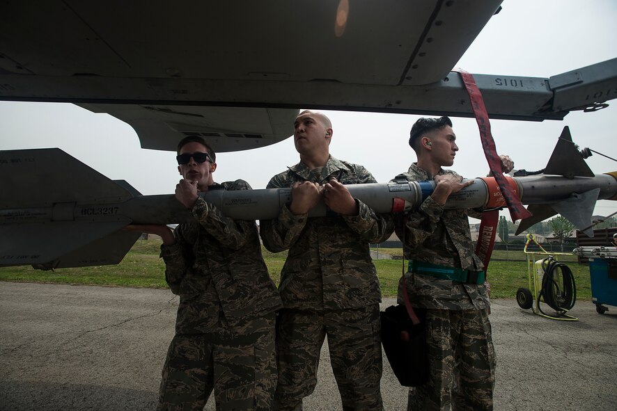 The 25th Aircraft Maintenance Unit weapons load crew team carries a missle to an A-10 during the 2014 Korean Peninsula Weapons Loading Competition April 26, at Osan Air Base, Republic of Korea. The 25th AMU's team consisted of Senior Airmen Chandler Rickard, Jacob Jennings and Juan Gonzalez. (U.S. Air Force photo by Staff Sgt. Jake Barreiro)