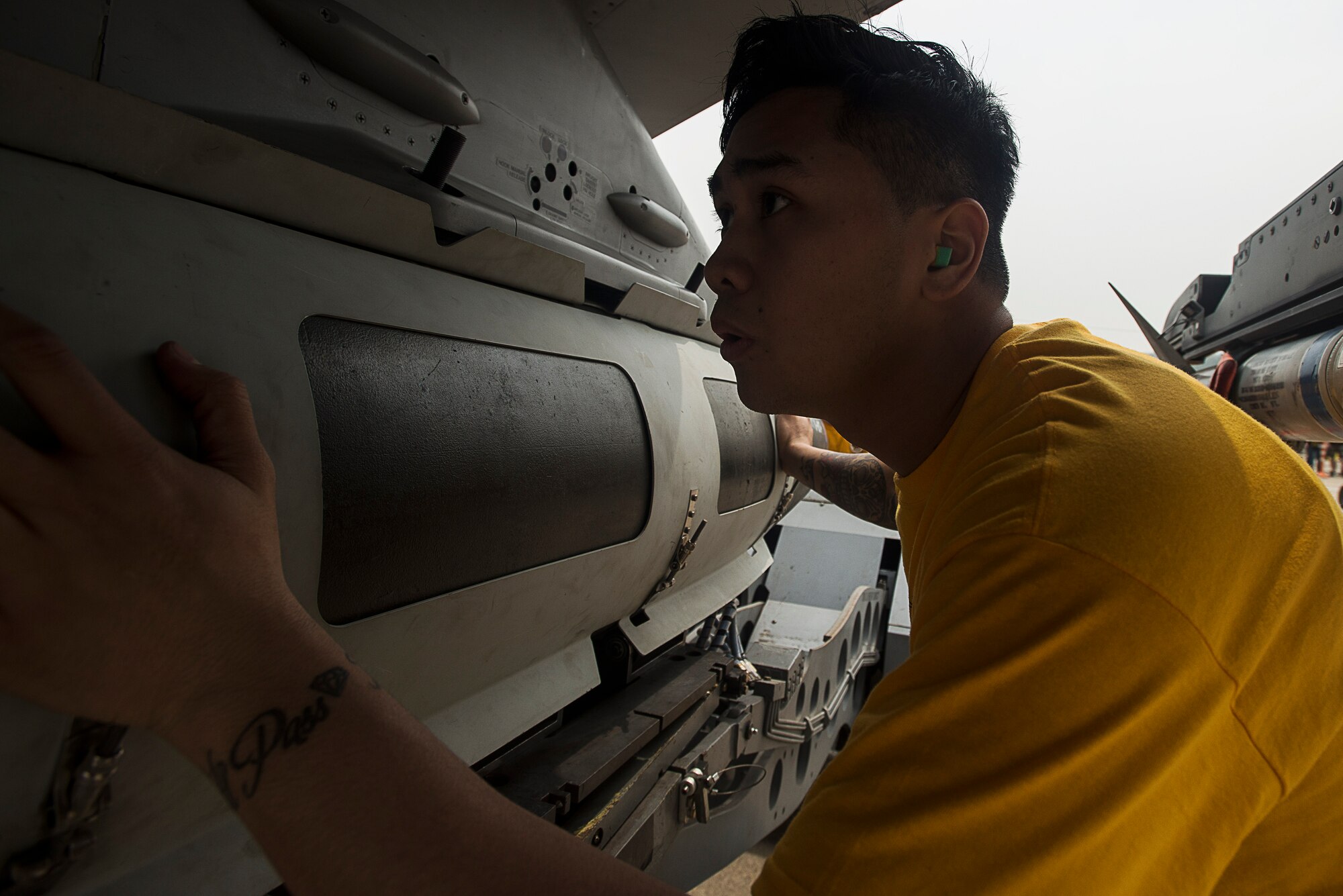 Senior Airman Ryanted Duarte, an 80th Aircraft Maintenance Unit weapons load crew member at Kunsan Air Base, Republic of Korea, guides a missle onto an F-16 during the 2014 Korean Peninsula Weapons Loading Competition April 26, at Osan Air Base. The 35th AMU from Kunsan AB and 36th and 25th AMU from Osan AB also competed. (U.S. Air Force photo by Staff Sgt. Jake Barreiro)