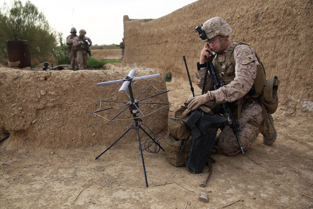 U.S. Marine Corps Sgt. Steven Olson talks on a satellite communications device during a mission in Larr village in Afghanistan's Helmand province, April 25, 2014.  Olson, a field radio operator, is assigned to Weapons Company, 1st Battalion, 7th Marine Regiment.