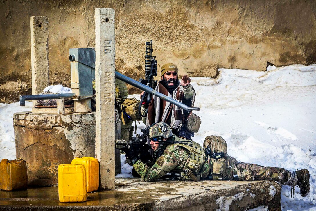 U.S. special forces soldiers provide security while an Afghan special forces soldier directs other Afghan soldiers during a firefight with insurgents in the Gelan district in Afghanistan's Ghazni province, Feb. 8, 2014.  