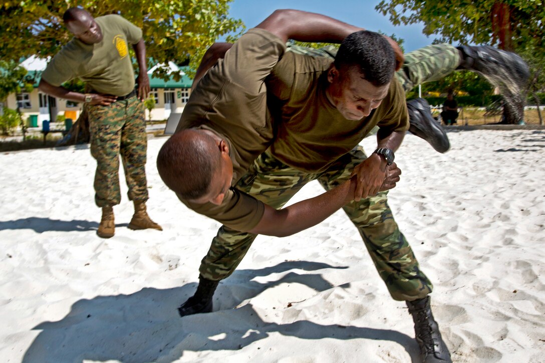 U.S. Marine Corps Sgt. Maxwell McCants observes as Maldivian marines practice hip throws while participating in the U.S. Marine Corps Martial Arts Program in Maafilaafushi, Maldives, Feb. 4, 2014. McCants is assigned to Mobile Training Team, U.S. Marine Corps Forces, Pacific.  