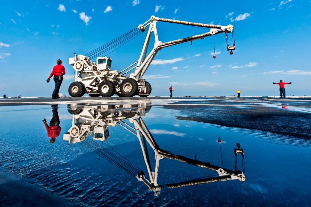 U.S. sailors assigned to the crash and salvage team transport a mobile salvage crane on the flight deck of the aircraft carrier USS Harry S. Truman in the U.S. 5th Fleet area of responsibility, Jan. 15, 2014. The Truman is conducting maritime security operations and supporting theater security cooperation efforts.  