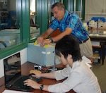 Japanese researcher Yukari Akatsuka, the secretary general of Kuentai-USA, a non-governmental group which specializes in locating and retrieving the remains of World War II dead, fires up her computer as New York State Military Museum Librarian Jim Gandy prepares records for her to scan on July 29, 2014. The group, which focuses on finding the remains of Japanese soldiers killed during World War II, is planning to conduct a dig where they think missing American Soldiers, who fought with the New York National Guard's 105th Infantry Regiment during World War II, may be buried. Akatsuka and a colleague visited the museum to go through data in hopes of refining the search area.