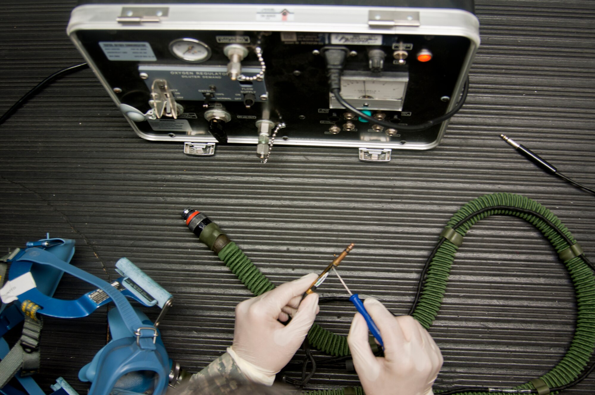 Senior Airman Abraham Sanchez demonstrates the process of repairing a KC-10 Extender quick-don mask July 24, 2014, at Travis Air Force Base, Calif. Sanchez is a 60th Operations Support Squadron aircrew flight equipment technician. (U.S. Air Force photo/Staff Sgt. John Ayre)