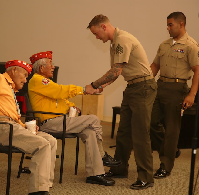 Sgt. Jake Smith, data chief, Marine Corps Logistics Operations Group, shakes hands with Bill Toledo, Dine Navajo Code Talker, after a presentation at the Protestant Chapel, July 11, 2014. Three code talkers, Bill Toledo, Robert Walley, and Alfred Peaches, gave their accounts of life as a code talker during World War II, and their experiences during battles in the Pacific Theater.