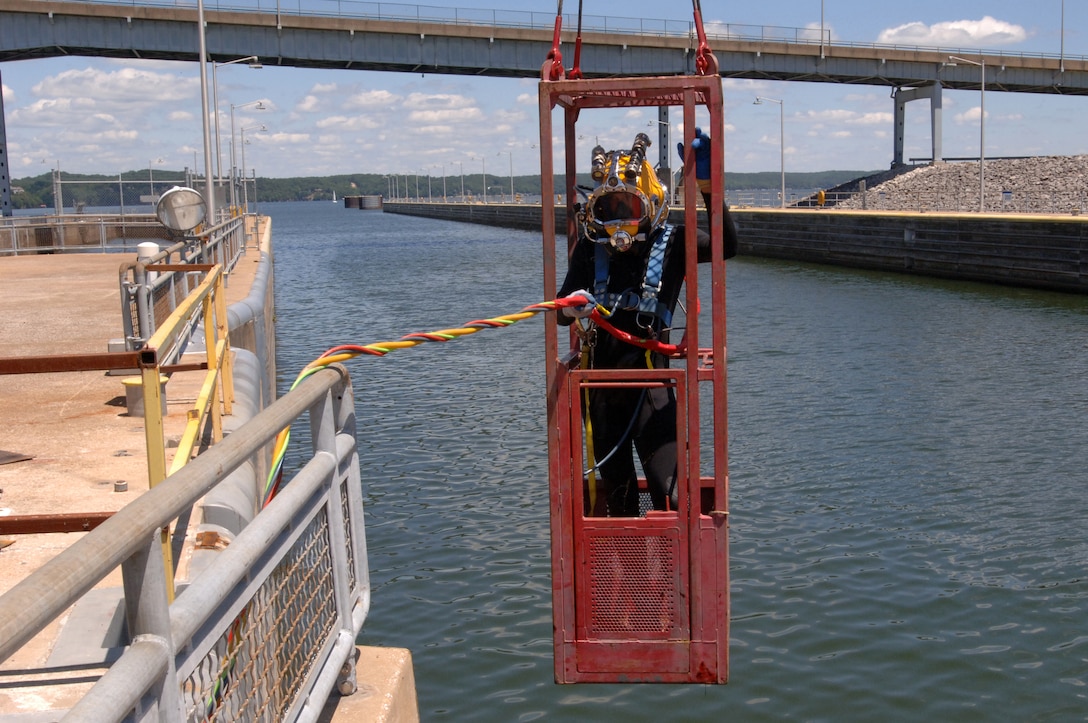 Diver Dustin Kelley, Nashville District Dive Team, is lowered into Pickwick Lock in Counce, Tenn., to inspect the lock gate and miter seal after the gate shook and experienced a malfunction early in the morning July 28, 2014.