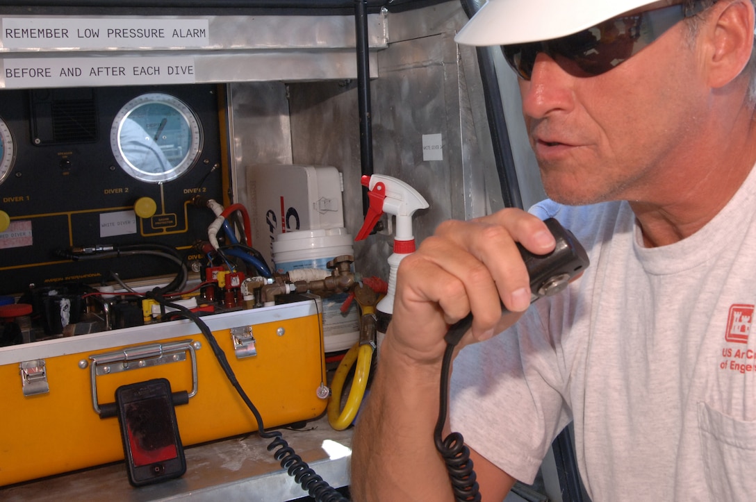 Gerald Choat, Nashville District Dive Team supervisor, communicates with the diver inspecting a gate underwater at Pickwick Lock in Counce, Tenn., July 28, 2014.