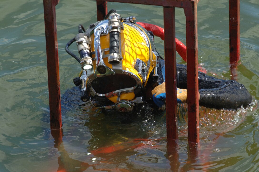 Diver Dustin Kelley, Nashville District Dive Team, descends into Pickwick Lock in Counce, Tenn., to inspect the lock gate and miter seal after the gate shook and experienced a malfunction early in the morning July 28, 2014.