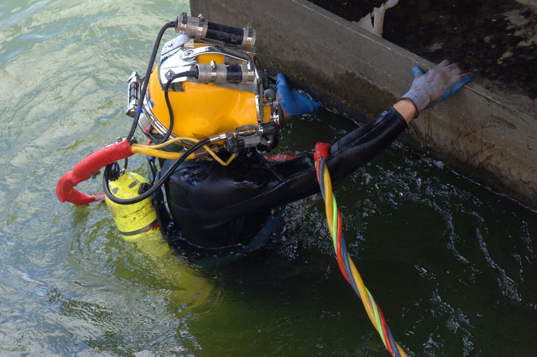 Diver Dustin Kelley, Nashville District Dive Team, inspects the lock gate after the gate shook and experienced a malfunction early in the morning at Pickwick Lock in Counce, Tenn., July 28, 2014.