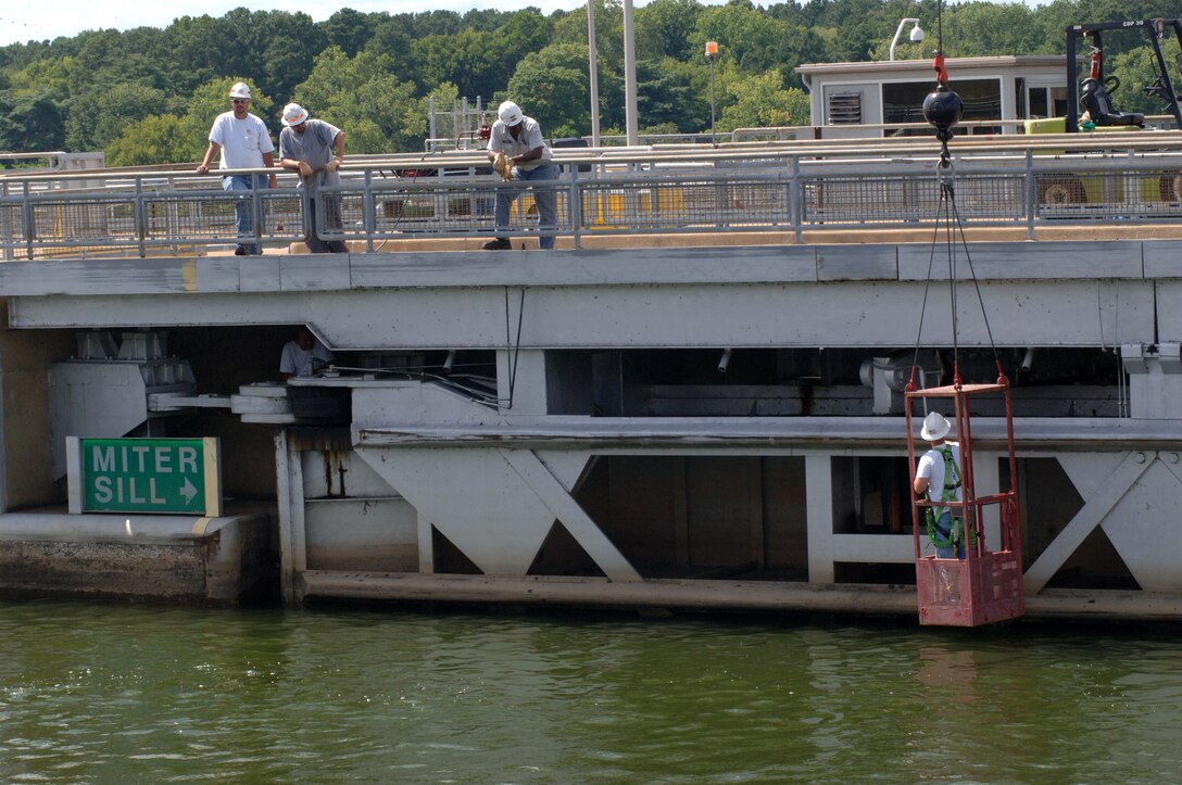 Jeff Neely, Nashville District Dive Team member and lockmaster at Cheatham Lock, inspects the gate at Pickwick Lock in Counce, Tenn., after the dive team inspected the gate and did not find any debris or damage to the underwater components. Other maintainers watch from above.