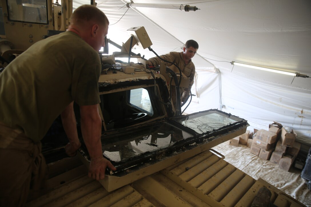 Corporal Rodney Franks, left, a motor transportation operator with 1st Battalion, 7th Marine Regiment, replaces a broken window on a Mine-Resistant Ambush Protected vehicle aboard Camp Leatherneck, Afghanistan, July 22, 2014. Franks, a native of San Bernardino, Calif., assists the mechanics in his spare time to help with maintenance performed on vehicles in the battalion to ensure mission success during combat operations.
(U.S. Marine Corps photo by Cpl. Joseph Scanlan / released)
