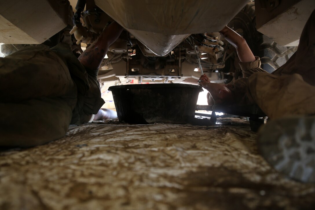 Motor transportation mechanics with 1st Battalion, 7th Marine Regiment, conduct maintenance from underneath a Mine-Resistant Ambush Protected vehicle aboard Camp Leatherneck, Afghanistan, July 22, 2014. The five lance corporal mechanics are the only mechanics responsible for all maintenance performed on vehicles in the battalion to ensure mission success during combat operations.
(U.S. Marine Corps photo by Cpl. Joseph Scanlan / released)
