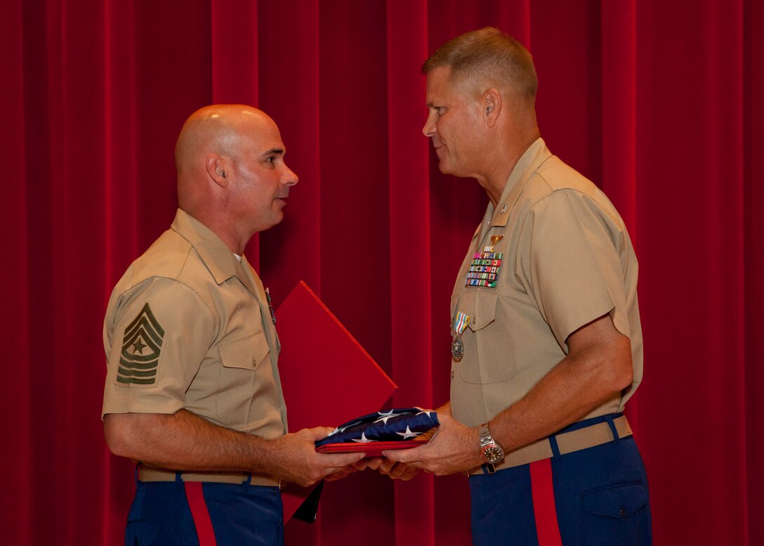 Sgt. Maj. Craig Cressman presents an American flag during a retirement ceremony in honor of Col. Frank S. Arnold at Fort Lesley J. McNair, Washington, D.C., Aug. 1, 2014. Col. Arnold served honorably in the U.S. Marine Corps for 27 years. (U.S. Marine Corps photo by Cpl. Tia Dufour/Released)
