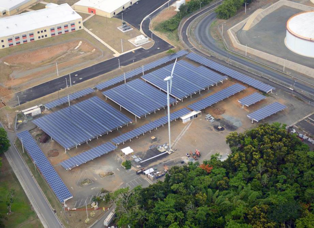 One of two wind turbines on Fort Buchanan stands next to one of its many solar installations. The two wind turbines will produce an estimated 5 percent of the energy consumed by the installation, and a total of 21,824 solar photovoltaic panels will produce about 5.5 megawatts of power, which is at least 60 percent of the installation’s current power demand at its peak production.
 