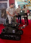 Maj Robert Gruber explains to LtGen Ronald Bailey the computer based control system that can be used to operate some of the robots on display at Marine Week Seattle.